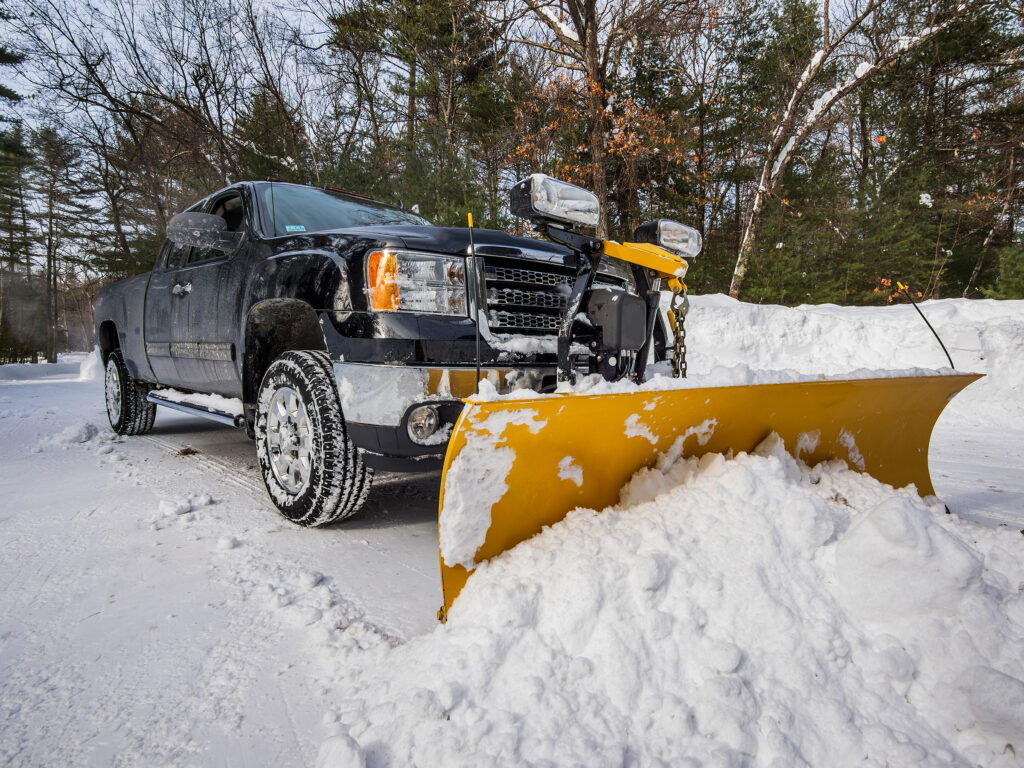 A sugarhouse property services snow plow at work plowing snow in vermont
