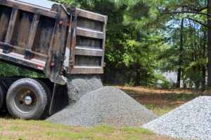 A dumptruck dumping gravel for a driveway repair