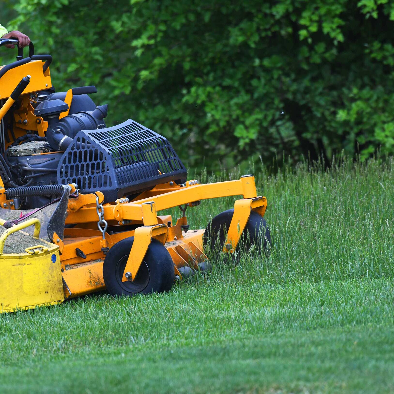 Sugarhouse Vermont employee mowing a lawn with a zero-turn ride-on mower